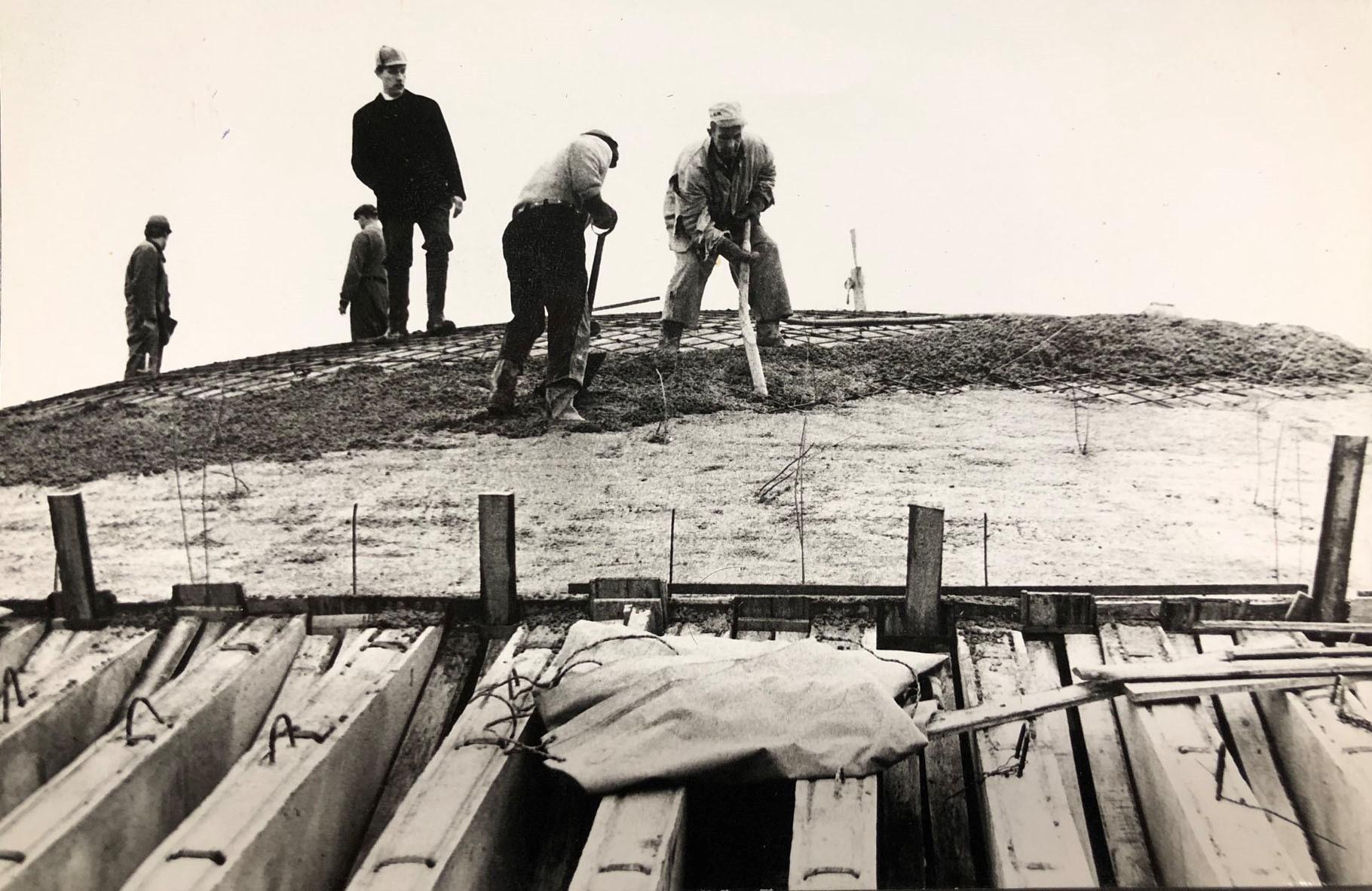 Viisi rakennusmiestä mustavalkoisessa kuvassa Temppeliaukion kirkon rakennustöissä.